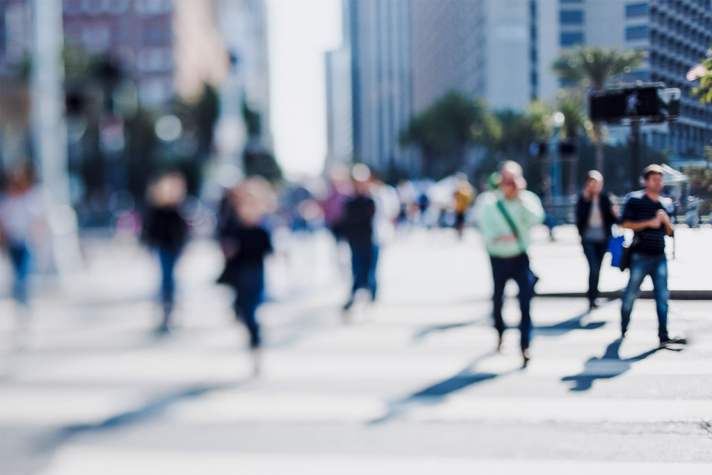 out of focus image of people in a big city rushing through the crossroad