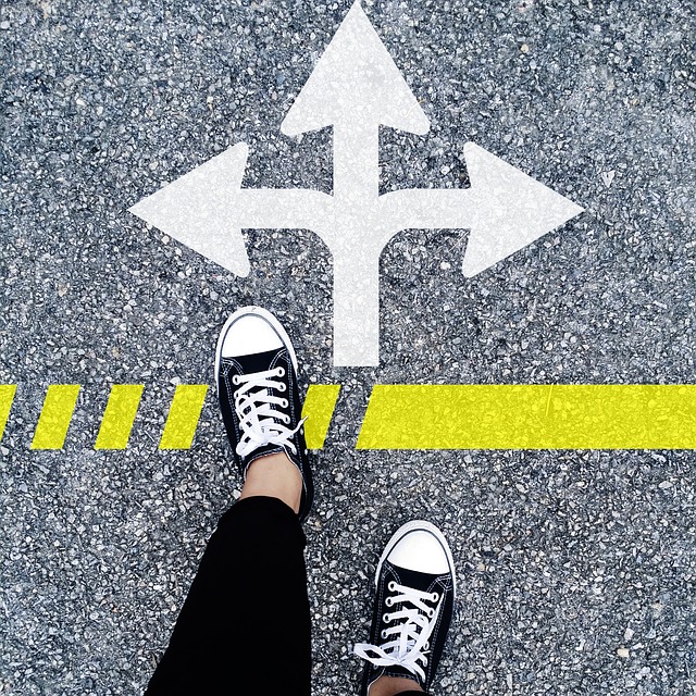 person standing at the crossing sign with different directions